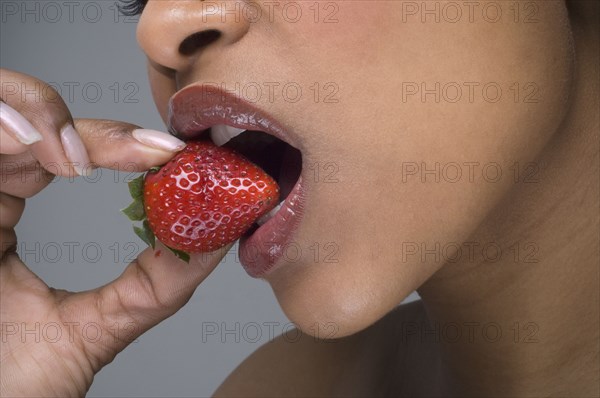 African woman eating strawberry