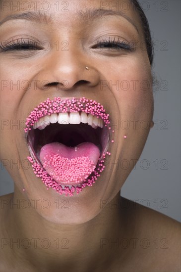 African woman laughing with sprinkles on lips