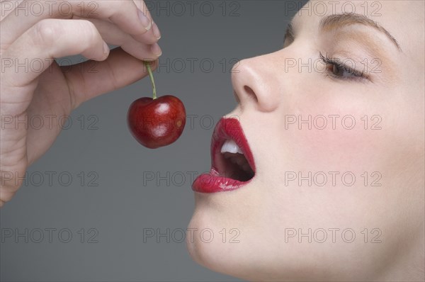 Woman eating cherry