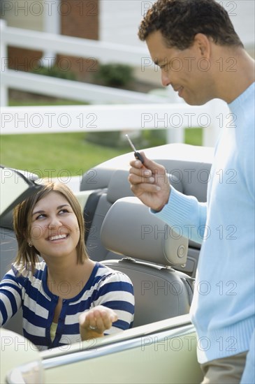 Hispanic father giving daughter car key