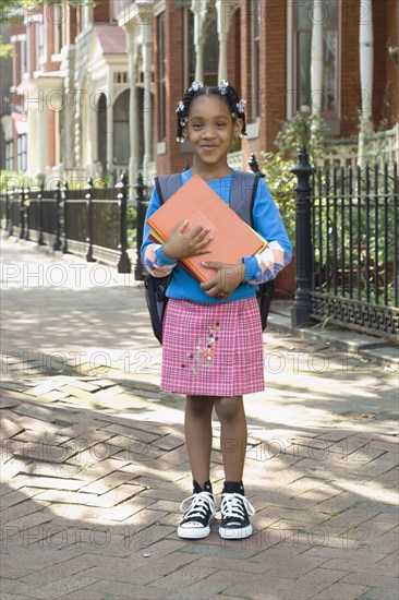 African girl holding school books