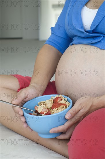 Pregnant African woman eating cereal