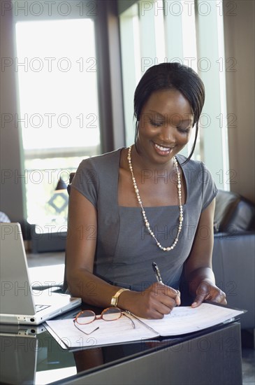 African businesswoman writing on calendar