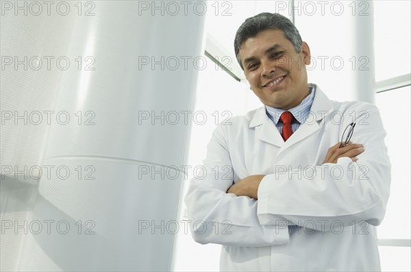 Hispanic male doctor with arms crossed