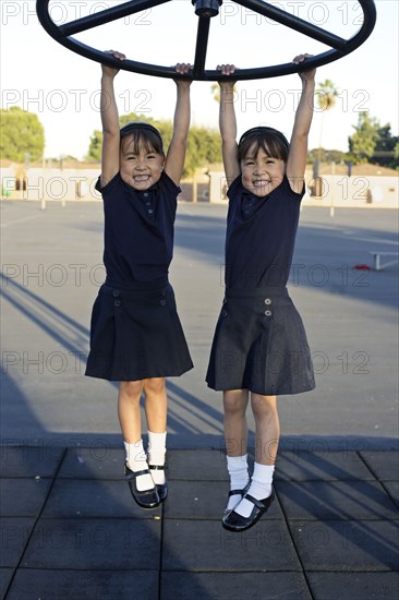 Twin girls playing on playground