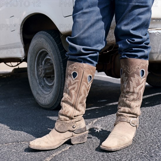 Close up of man wearing cowboy boots with spurs