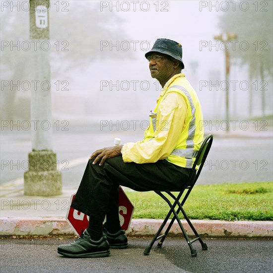 Crossing guard sitting at crosswalk