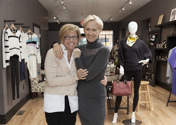 Caucasian small business owners working in clothing store