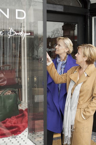 Older Caucasian women window shopping in clothing store