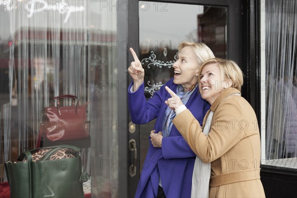 Older Caucasian women window shopping in clothing store