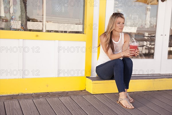 Caucasian woman drinking juice outside restaurant