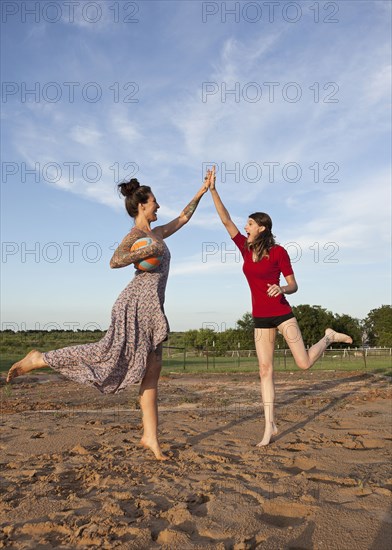 Caucasian women high fiving in rural field