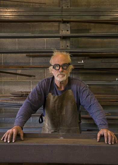 Portrait of serious Caucasian blacksmith in workshop