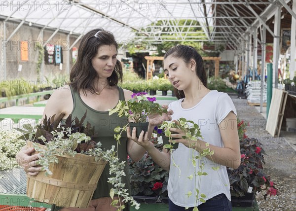 Caucasian mother and daughter shopping for flowers