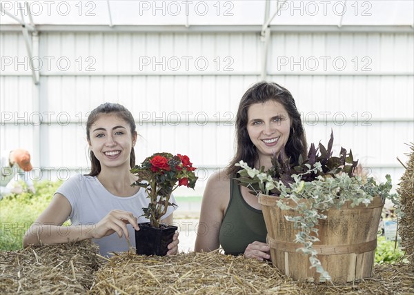 Portrait of Caucasian mother and daughter holding flowers