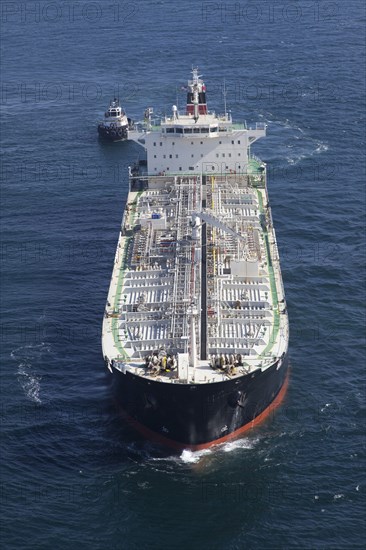 Oil tanker with tugboat at sea