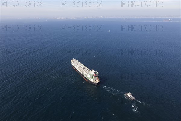 Oil tanker with tugboat at sea