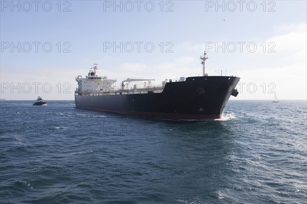 Oil tanker with tugboat at sea