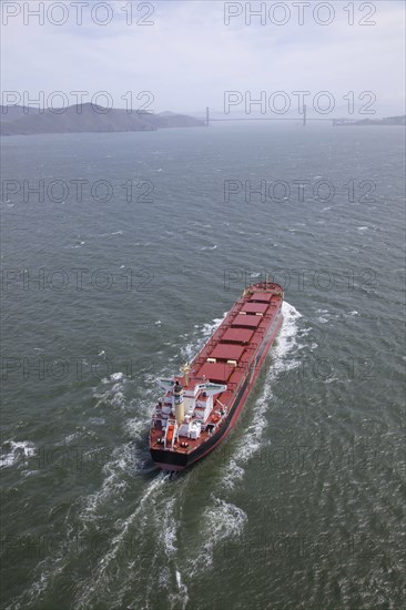 Aerial view of container ship in urban harbor