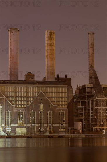 Factory smokestacks lit up at night