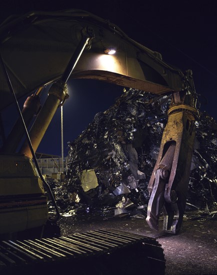 Mechanical grabber in junkyard at night