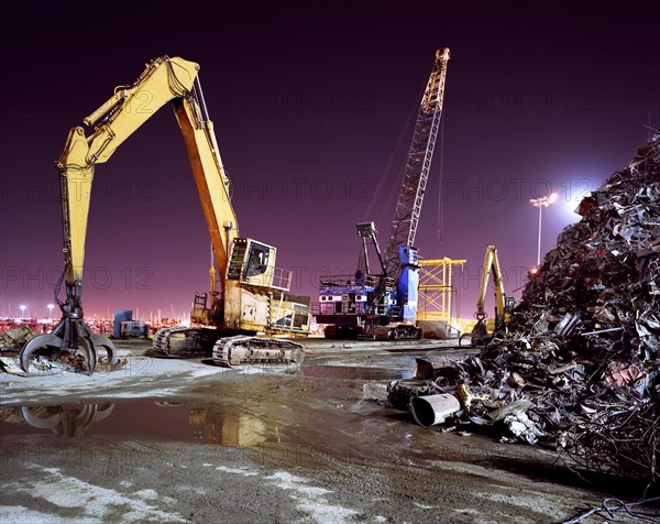 Mechanical grabber in junkyard at night