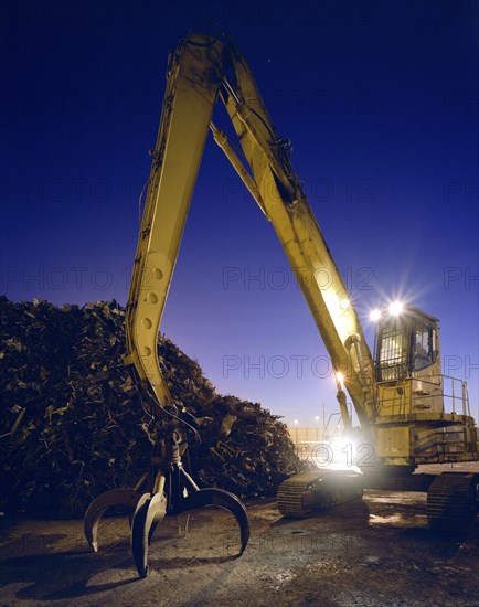 Mechanical grabber in junkyard at night