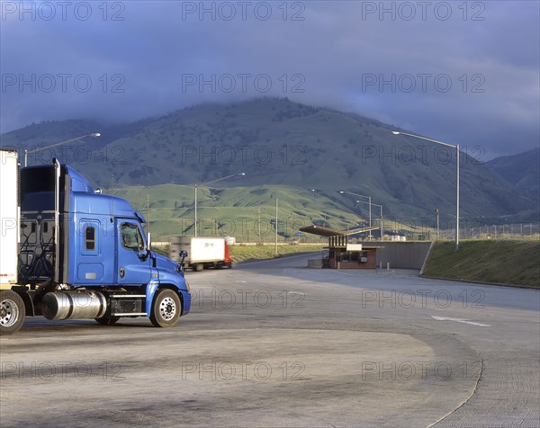 Blue semi-truck following arrows on road