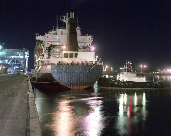 Tugboat and ship moored in harbor