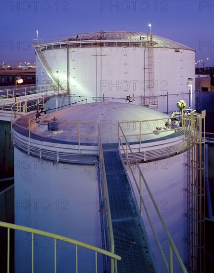 Footbridge on storage tanks at night