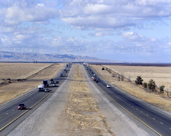 Cars and semi-trucks driving on freeway