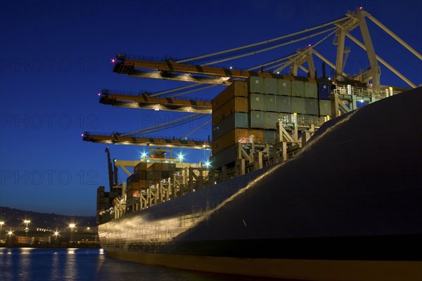 Cargo containers on freighter in port at night