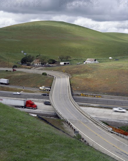 Trucks and cars driving under freeway overpass