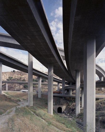 Trucks and cars driving under freeway overpass