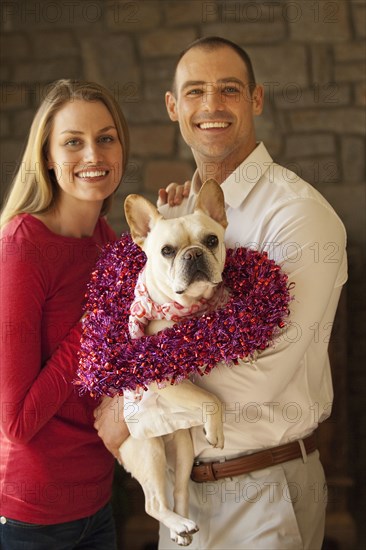 Caucasian couple holding dog