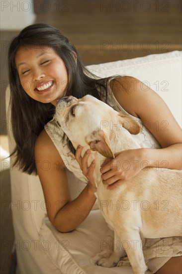 Dog licking Asian woman