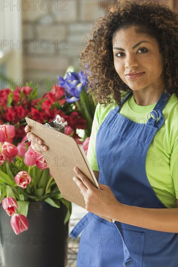 Mixed race florist holding clipboard