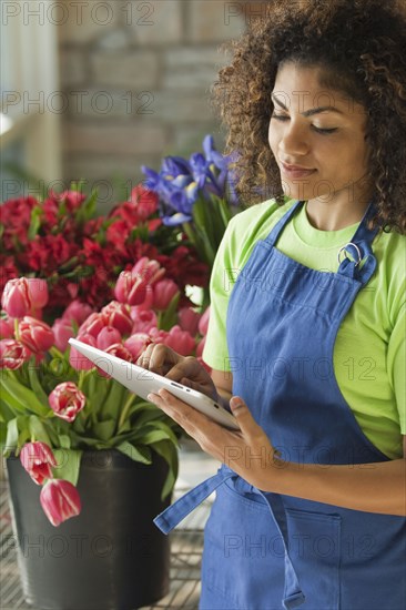 Mixed race florist using digital tablet