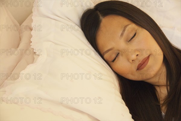 Asian woman sleeping in bed