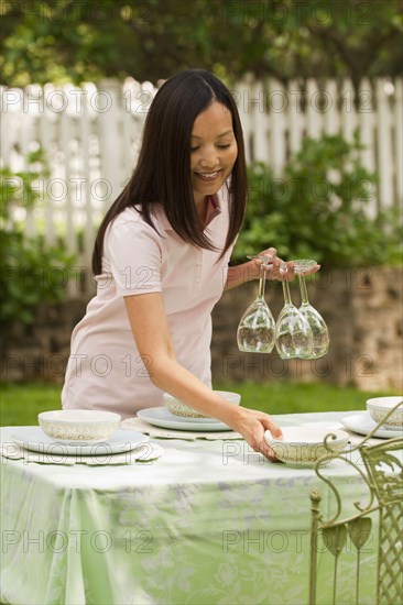 Asian woman setting table outdoors