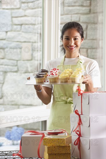 Smiling baker packing cupcakes