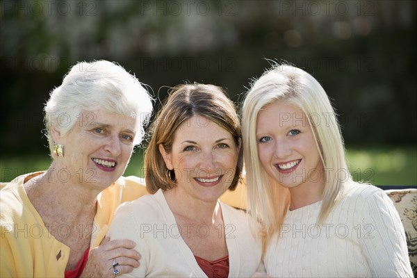 Three generations of Caucasian women smiling outdoors