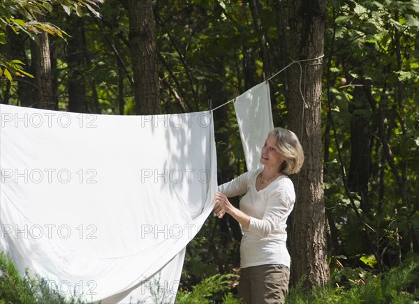 Caucasian woman hanging sheets outdoors