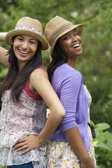 Women standing back to back outdoors