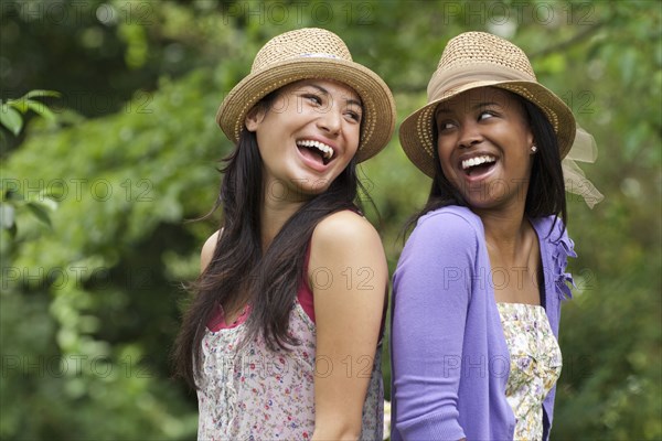 Women standing back to back outdoors