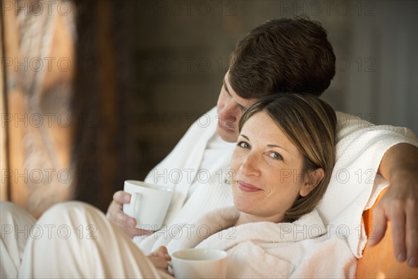 Caucasian couple drinking coffee in bathrobes