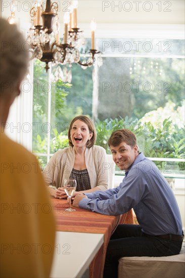 Caucasian mother surprising couple at table