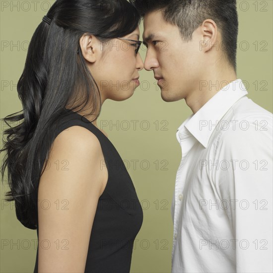 Studio shot of Asian couple head to head