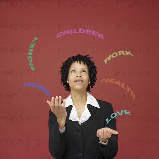 African businesswoman juggling words representing busy life