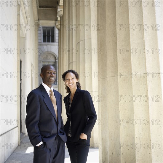 Portrait of businesswoman and businessman next to columns